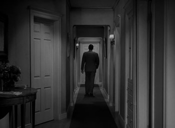 Movie still from “Gentleman's Agreement” (1947), directed by Elia Kazan – A man walking down a long hallway in a suit; Wide shot, High angle