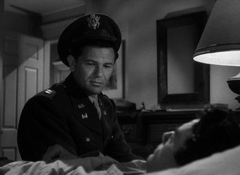 Movie still from “Gentleman's Agreement” (1947), directed by Elia Kazan – A man in a military uniform sitting in front of a woman; Medium shot, Low angle