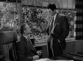 Movie still from “Gentleman's Agreement” (1947), directed by Elia Kazan – Two men in suits talking to each other in an office setting; Medium shot, Over the shoulder angle