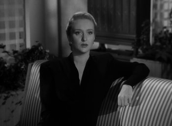 Movie still from “Gentleman's Agreement” (1947), directed by Elia Kazan – A black and white photo of a woman sitting on a couch; Close Up shot, High angle