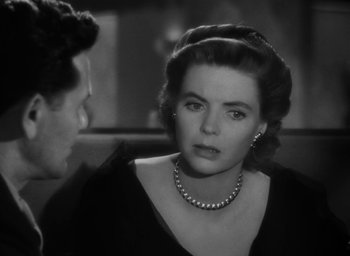 Movie still from “Gentleman's Agreement” (1947), directed by Elia Kazan – A woman wearing a black dress and a pearl necklace; Close Up shot, Over the shoulder angle