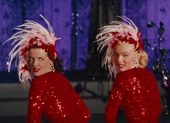 Movie still from “Gentlemen Prefer Blondes” (1953), directed by Howard Hawks – A couple of women standing next to each other on a stage; Medium shot, Low angle