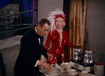 Movie still from “Gentlemen Prefer Blondes” (1953), directed by Howard Hawks – A man and a woman in a red dress; Medium shot, High angle