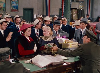 Movie still from “Gentlemen Prefer Blondes” (1953), directed by Howard Hawks – A group of men and women wearing hats; Medium shot, Over the shoulder angle