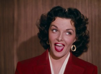 Movie still from “Gentlemen Prefer Blondes” (1953), directed by Howard Hawks – A woman in a red jacket is smiling; Close Up shot, Low angle