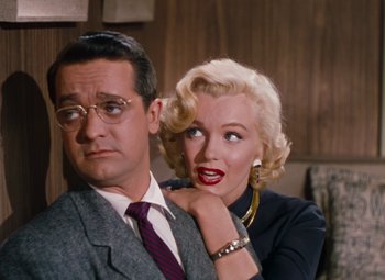 Movie still from “Gentlemen Prefer Blondes” (1953), directed by Howard Hawks – A man and a woman posing for a picture together; Medium shot, Over the shoulder angle