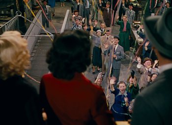 Movie still from “Gentlemen Prefer Blondes” (1953), directed by Howard Hawks – A group of people standing on the side of a road; Extreme Wide shot, High angle