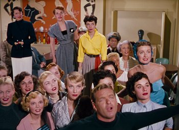 Movie still from “Gentlemen Prefer Blondes” (1953), directed by Howard Hawks – A group of people that are posing for a picture; Wide shot, High angle