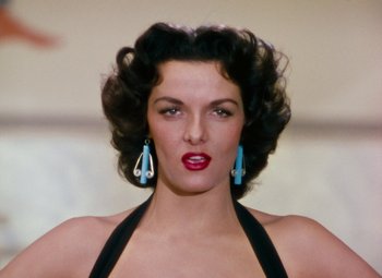 Movie still from “Gentlemen Prefer Blondes” (1953), directed by Howard Hawks – A beautiful woman with red lipstick and blue earrings; Close Up shot, Low angle