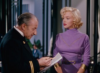 Movie still from “Gentlemen Prefer Blondes” (1953), directed by Howard Hawks – An older man and a young woman in a purple dress; Medium shot, Over the shoulder angle