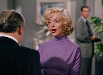 Movie still from “Gentlemen Prefer Blondes” (1953), directed by Howard Hawks – A woman in a purple dress talking to a man in a suit; Medium shot, Over the shoulder angle