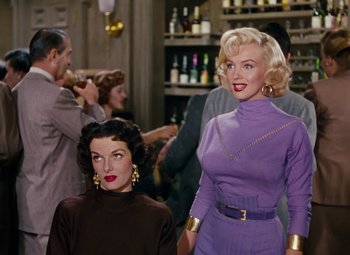 Movie still from “Gentlemen Prefer Blondes” (1953), directed by Howard Hawks – Two women are standing next to each other in front of a group of people; Medium shot, Low angle