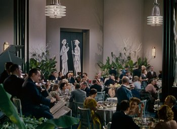 Movie still from “Gentlemen Prefer Blondes” (1953), directed by Howard Hawks – A group of people sitting at tables in a room; Extreme Wide shot, High angle