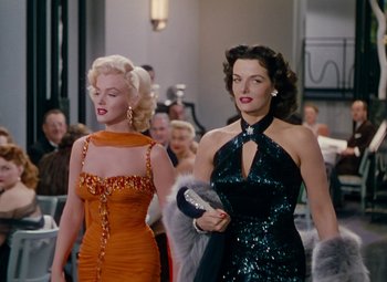 Movie still from “Gentlemen Prefer Blondes” (1953), directed by Howard Hawks – Two beautiful women walking down the street in dresses; Medium shot, Low angle