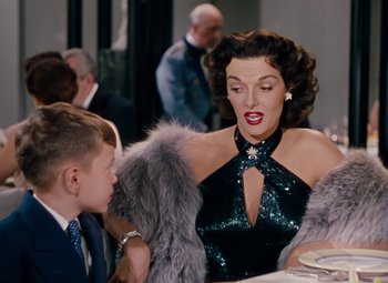 Movie still from “Gentlemen Prefer Blondes” (1953), directed by Howard Hawks – A woman and a boy are sitting at a table; Medium shot, Over the shoulder angle
