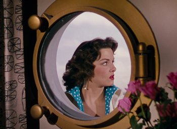 Movie still from “Gentlemen Prefer Blondes” (1953), directed by Howard Hawks – A woman looking into a mirror with a flower in front of it; Close Up shot, Overhead angle