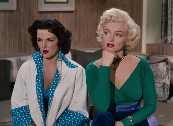 Movie still from “Gentlemen Prefer Blondes” (1953), directed by Howard Hawks – Two women sitting next to each other on a couch; Medium shot, High angle