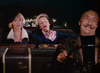 Movie still from “Gentlemen Prefer Blondes” (1953), directed by Howard Hawks – A group of people sitting in the back of a car; Medium shot, Over the shoulder angle