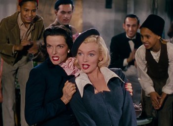 Movie still from “Gentlemen Prefer Blondes” (1953), directed by Howard Hawks – A group of people that are standing around each other; Medium shot, Low angle
