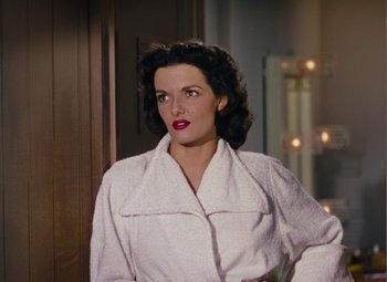 Movie still from “Gentlemen Prefer Blondes” (1953), directed by Howard Hawks – A woman in a white bathrobe standing next to a door; Medium shot, High angle