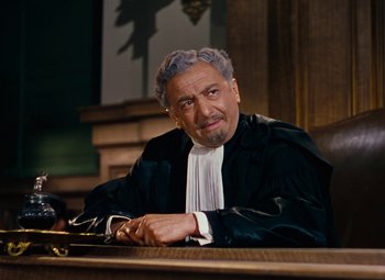 Movie still from “Gentlemen Prefer Blondes” (1953), directed by Howard Hawks – A man in a court room wearing a robe; Medium shot, Low angle