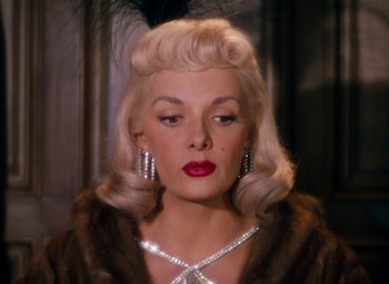 Movie still from “Gentlemen Prefer Blondes” (1953), directed by Howard Hawks – A woman with blonde hair wearing a fur coat and diamond earrings; Close Up shot, Over the shoulder angle