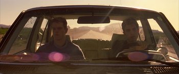 Movie still from “Gerry” (2002), directed by Gus Van Sant – Two men sitting in the back seat of a car; Medium shot, Low angle