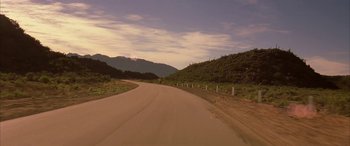 Movie still from “Gerry” (2002), directed by Gus Van Sant – A dirt road going through the middle of the desert; Extreme Wide shot, High angle
