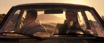 Movie still from “Gerry” (2002), directed by Gus Van Sant – Two men in the back seat of a car looking out the window; Medium shot, Low angle