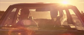 Movie still from “Gerry” (2002), directed by Gus Van Sant – A man sitting in the back seat of a car in the sunlight; Medium shot, Low angle