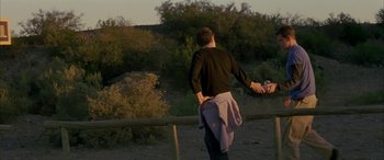 Movie still from “Gerry” (2002), directed by Gus Van Sant – A man standing on top of a dirt field; Medium shot, Over the shoulder angle