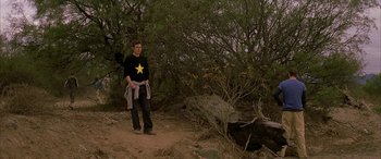 Movie still from “Gerry” (2002), directed by Gus Van Sant – A man standing in the middle of a dirt field; Wide shot, High angle