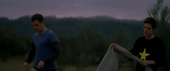 Movie still from “Gerry” (2002), directed by Gus Van Sant – Two people standing in front of a mountain range; Medium shot, Low angle