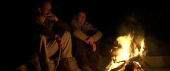 Movie still from “Gerry” (2002), directed by Gus Van Sant – A couple of men sitting next to each other; Medium shot, Low angle