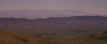 Movie still from “Gerry” (2002), directed by Gus Van Sant – A view of a desert landscape at dusk; Extreme Wide shot, High angle