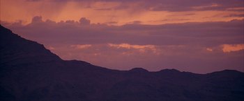 Movie still from “Gerry” (2002), directed by Gus Van Sant – A view of a mountain range at sunset; Extreme Wide shot, Low angle