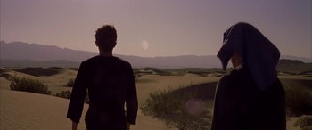 Movie still from “Gerry” (2002), directed by Gus Van Sant – Two people standing in the desert looking out at the sky; Wide shot, Low angle