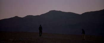 Movie still from “Gerry” (2002), directed by Gus Van Sant – A man standing in the desert at night; Extreme Wide shot, Low angle
