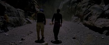 Movie still from “Gerry” (2002), directed by Gus Van Sant – Two men are walking on a dirt path; Wide shot, Low angle