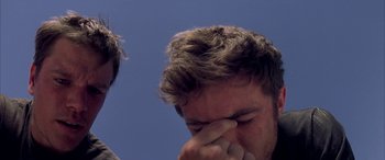 Movie still from “Gerry” (2002), directed by Gus Van Sant – A person holding his head with one hand; Close Up shot, Low angle