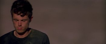 Movie still from “Gerry” (2002), directed by Gus Van Sant – A man standing in front of a white wall; Close Up shot, Low angle