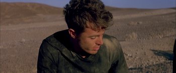 Movie still from “Gerry” (2002), directed by Gus Van Sant – A young man is looking down at the ground; Close Up shot, High angle