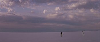 Movie still from “Gerry” (2002), directed by Gus Van Sant – A person standing in the middle of a vast expanse; Extreme Wide shot, High angle