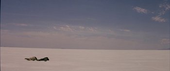 Movie still from “Gerry” (2002), directed by Gus Van Sant – A view of the sky from a distance looking across a vast expanse; Extreme Wide shot, Low angle