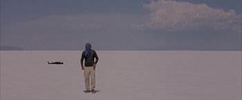 Movie still from “Gerry” (2002), directed by Gus Van Sant – A man standing in the middle of an empty field; Wide shot, Low angle