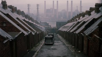 Movie still from “Get Carter” (1971), directed by Mike Hodges – Two cars parked on a street in an industrial area; Extreme Wide shot, High angle