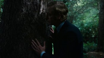 Movie still from “Get Carter” (1971), directed by Mike Hodges – A man leaning against a tree with his hands on his chest; Medium shot, Low angle