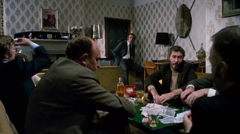 Movie still from “Get Carter” (1971), directed by Mike Hodges – A group of men sitting at a table playing cards; Medium shot, Over the shoulder angle
