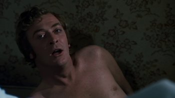 Movie still from “Get Carter” (1971), directed by Mike Hodges – A shirtless man is laying on the bed; Close Up shot, High angle