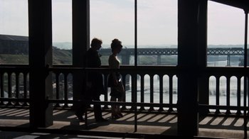 Movie still from “Get Carter” (1971), directed by Mike Hodges – Two people are standing on a balcony looking out at a bridge; Wide shot, High angle